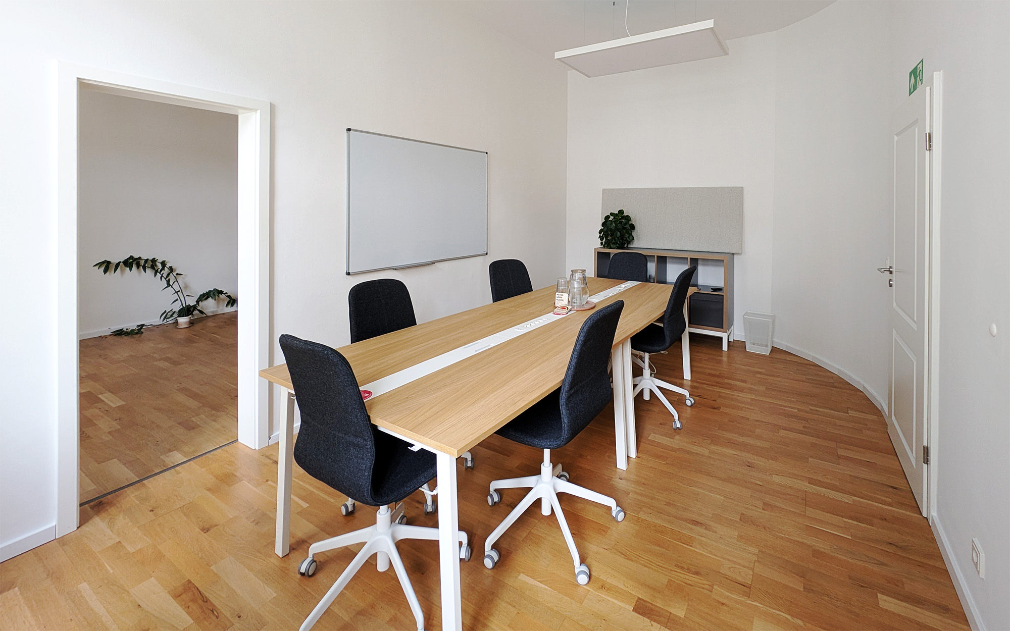 Meetingraum mieten Dresden Neustadt Harat: Lichter Besprechungsraum mit Tisch für 6 Personen, Whiteboard und Parkett.