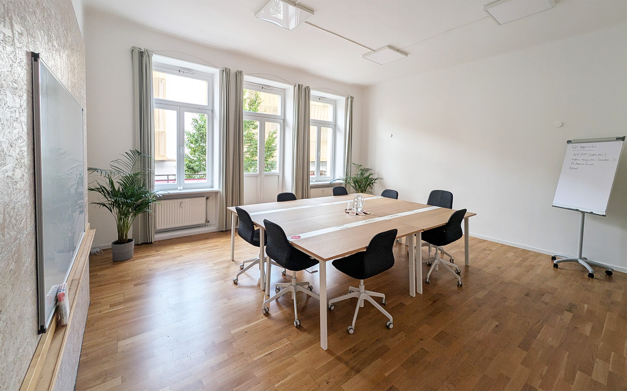 Meetingraum mieten Dresden Neustadt Mazarin: Großer Raum für 10 Personen mit Parkett, drei Fenstern und Pflanzen.